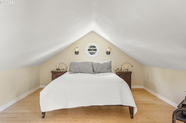 bedroom featuring light hardwood / wood-style flooring and lofted ceiling