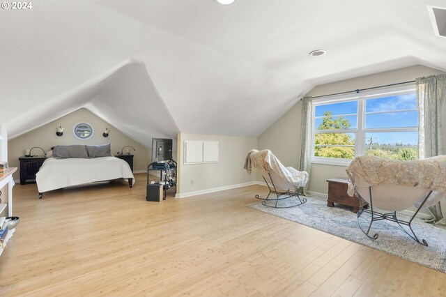 bedroom featuring light hardwood / wood-style floors and lofted ceiling