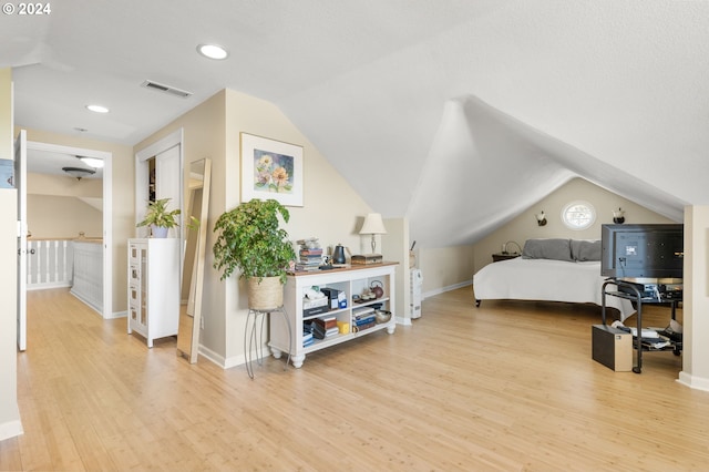 bedroom with light hardwood / wood-style flooring and lofted ceiling