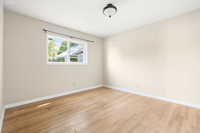 empty room with light hardwood / wood-style flooring