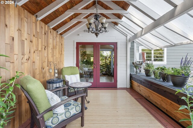 interior space featuring french doors, lofted ceiling with beams, and an inviting chandelier