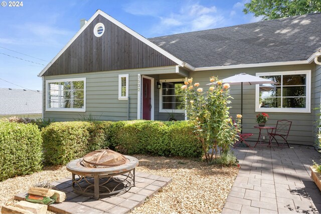 rear view of house featuring a fire pit and a patio area