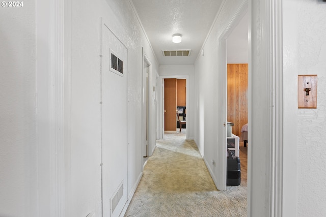 hallway featuring a textured ceiling and light carpet