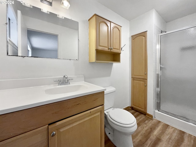 bathroom featuring vanity, toilet, walk in shower, and hardwood / wood-style floors