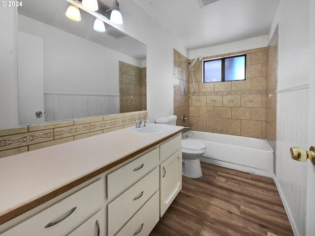 full bathroom featuring vanity, toilet, hardwood / wood-style flooring, and tiled shower / bath