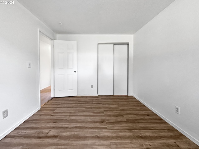 unfurnished bedroom featuring dark hardwood / wood-style floors and a closet