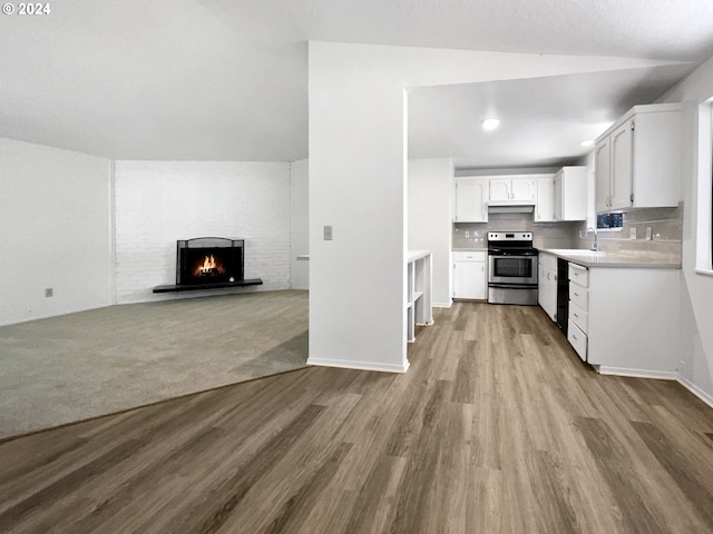 kitchen featuring white cabinetry, backsplash, stainless steel electric range, and wood-type flooring