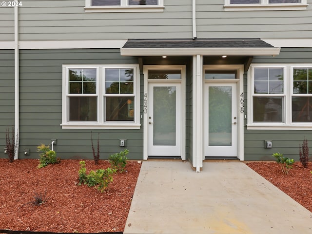 view of exterior entry with a shingled roof