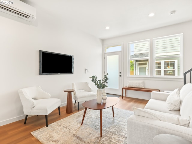 living room with light wood-type flooring and an AC wall unit