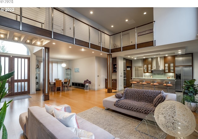 living room featuring a high ceiling and light hardwood / wood-style flooring