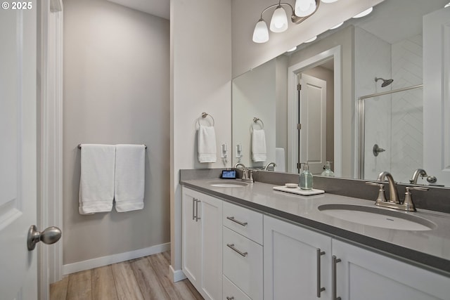 bathroom with a shower with door, vanity, and hardwood / wood-style flooring