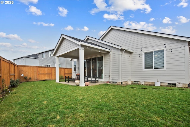 rear view of house featuring a patio area and a yard