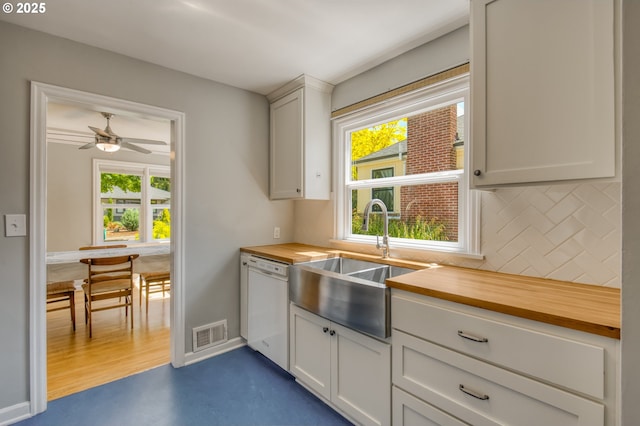 kitchen featuring butcher block countertops, a sink, decorative backsplash, dishwasher, and ceiling fan