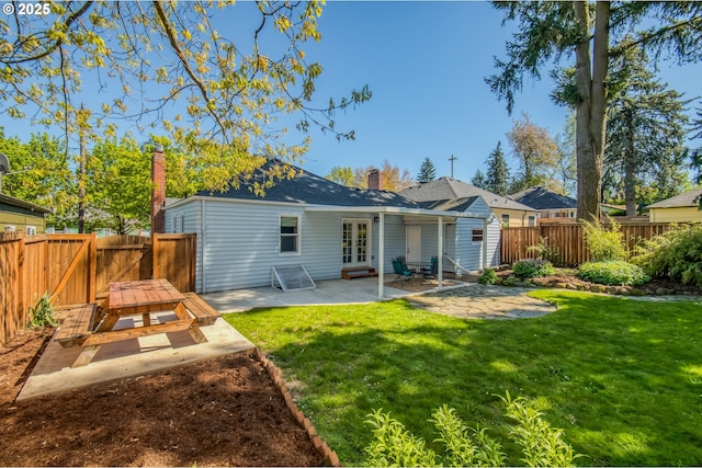back of property featuring french doors, a patio, a chimney, and a gate