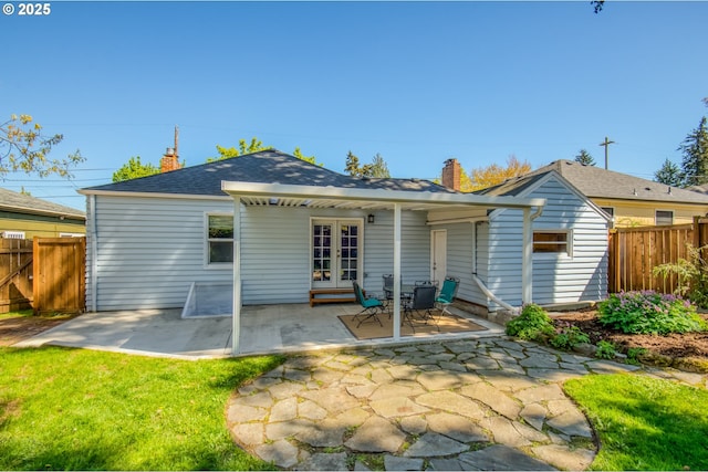 back of house featuring french doors, a chimney, and a patio area