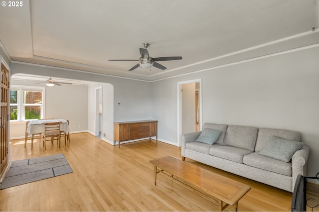 living area featuring ceiling fan, light wood finished floors, and baseboards