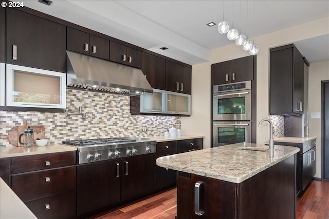 kitchen featuring backsplash, dark wood-type flooring, decorative light fixtures, and appliances with stainless steel finishes