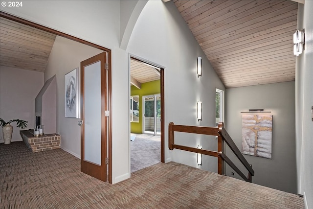 hallway featuring carpet flooring, vaulted ceiling, and wood ceiling