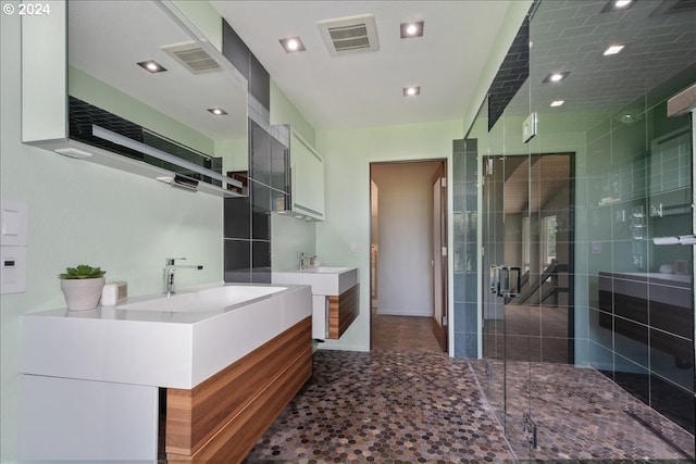 bathroom with vanity and a shower with door