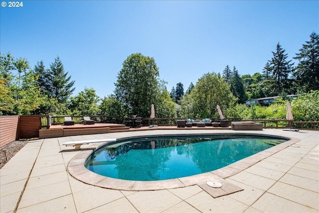 view of pool featuring a patio area and a diving board