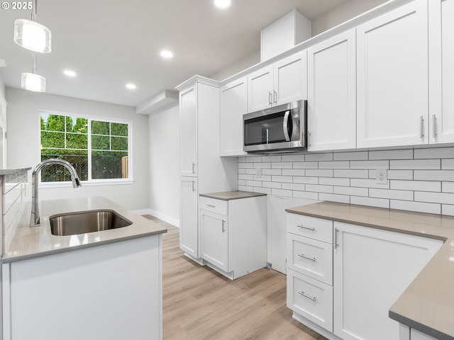 kitchen with pendant lighting, white cabinets, and sink