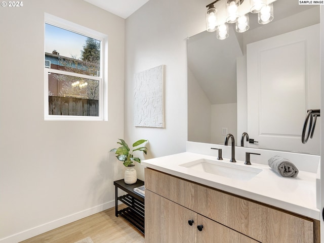 bathroom with a chandelier, wood-type flooring, and oversized vanity