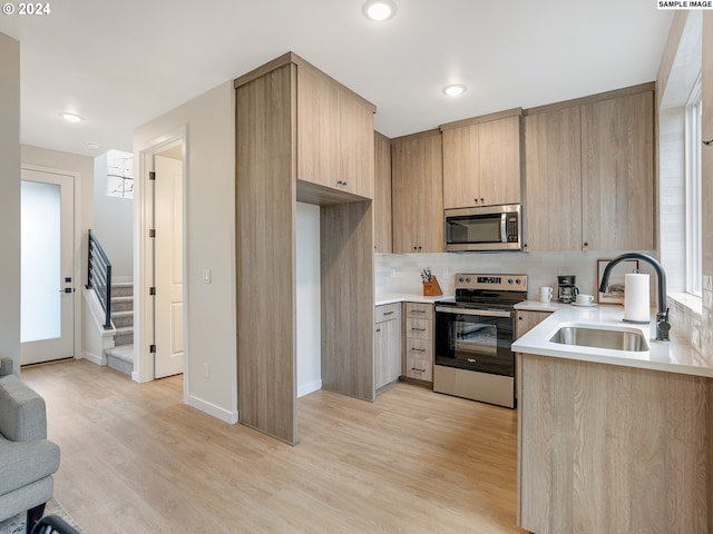 kitchen featuring light hardwood / wood-style floors, tasteful backsplash, stainless steel appliances, light brown cabinetry, and sink