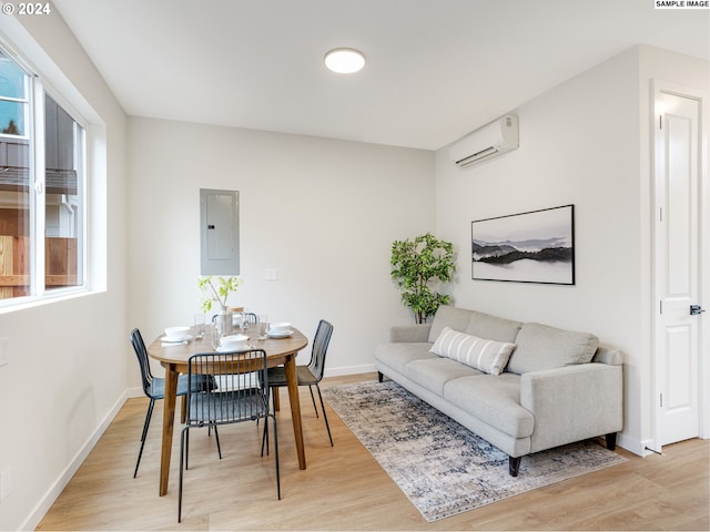 living room with plenty of natural light, light hardwood / wood-style flooring, and a wall mounted air conditioner