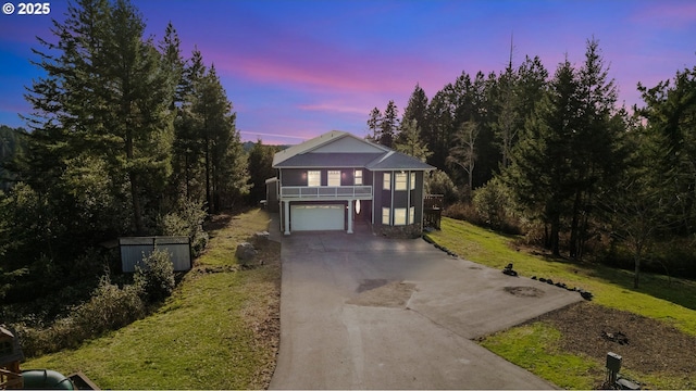 view of front facade featuring a lawn, a garage, and a balcony