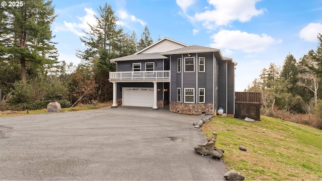 view of front property featuring a balcony, a garage, and a front lawn