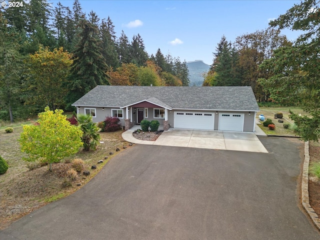 ranch-style house featuring a garage and a mountain view