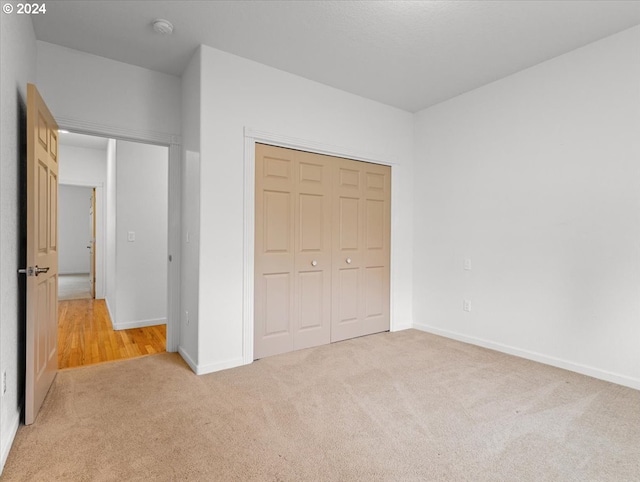 unfurnished bedroom with carpet flooring and a closet