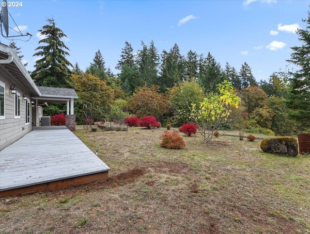 view of yard with a deck and central AC