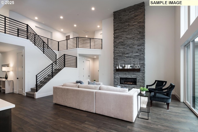 1004 S Mountain Pl, Ridgefield, WA 98642 - living room with a towering ceiling, stairway, dark wood-style floors, a stone fireplace, and recessed lighting