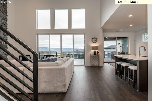 1004 S Mountain Pl, Ridgefield, WA 98642 - living room featuring dark wood-type flooring, stairs, a high ceiling, and recessed lighting