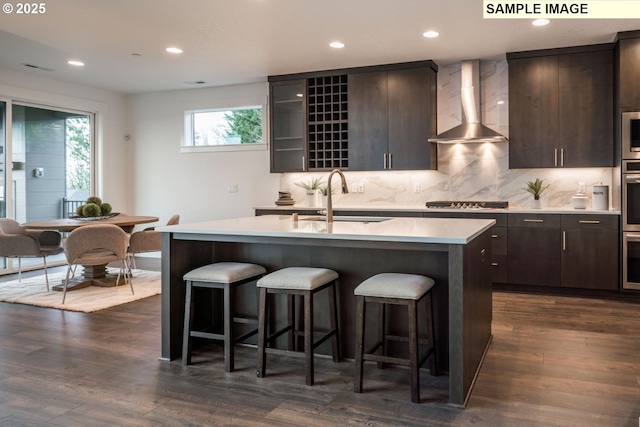 1004 S Mountain Pl, Ridgefield, WA 98642 - kitchen featuring wall chimney exhaust hood, a kitchen breakfast bar, light countertops, a sink, and recessed lighting