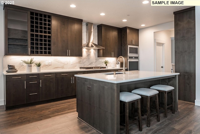 1004 S Mountain Pl, Ridgefield, WA 98642 - kitchen with wall chimney exhaust hood, a sink, stainless steel appliances, dark wood-style floors, and a kitchen breakfast bar