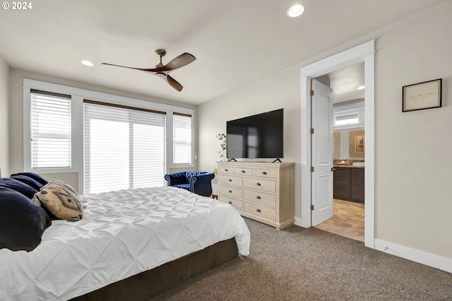 bedroom with light carpet, ceiling fan, and connected bathroom