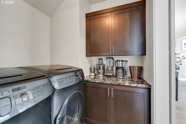 clothes washing area featuring cabinets and washing machine and clothes dryer