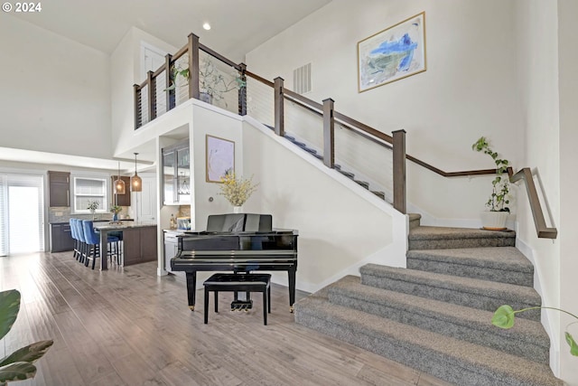 staircase with a high ceiling and hardwood / wood-style floors