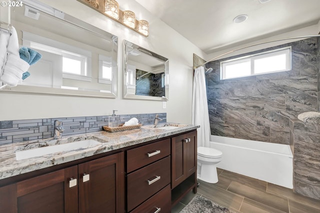 full bathroom featuring vanity, wood-type flooring, shower / tub combo, toilet, and decorative backsplash