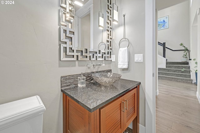 bathroom with vanity, toilet, and hardwood / wood-style flooring