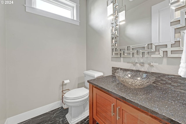 bathroom with tasteful backsplash, vanity, and toilet