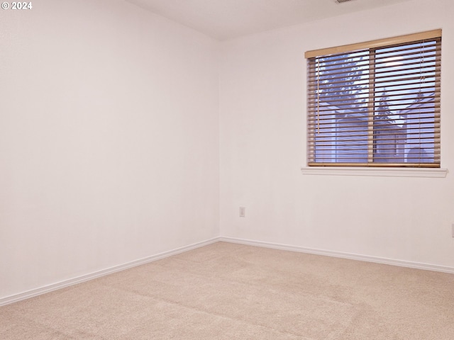 unfurnished room featuring light colored carpet