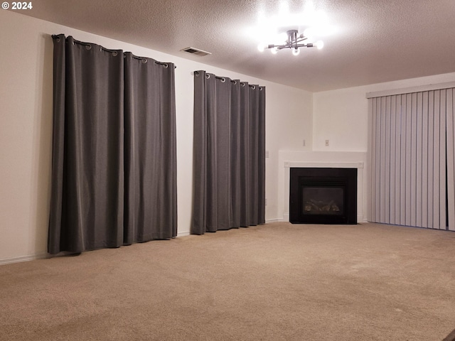 unfurnished living room featuring a textured ceiling, light colored carpet, and an inviting chandelier