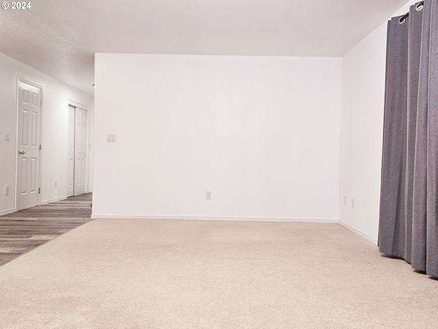 spare room featuring a textured ceiling and hardwood / wood-style flooring