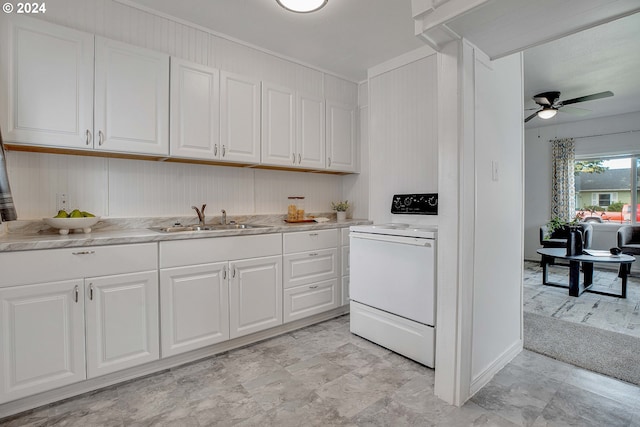 kitchen featuring white cabinets, white range, ceiling fan, sink, and light colored carpet