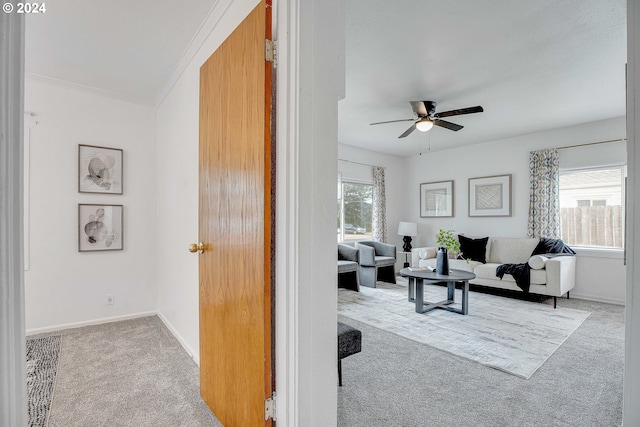 living room with crown molding, light carpet, and ceiling fan