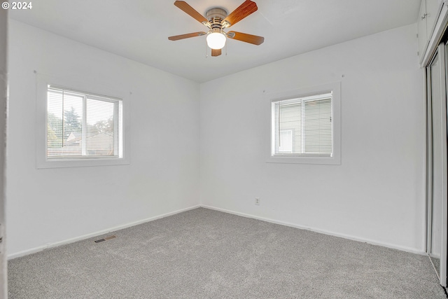 carpeted spare room with ceiling fan