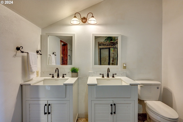 bathroom featuring vanity, toilet, lofted ceiling, and a textured ceiling